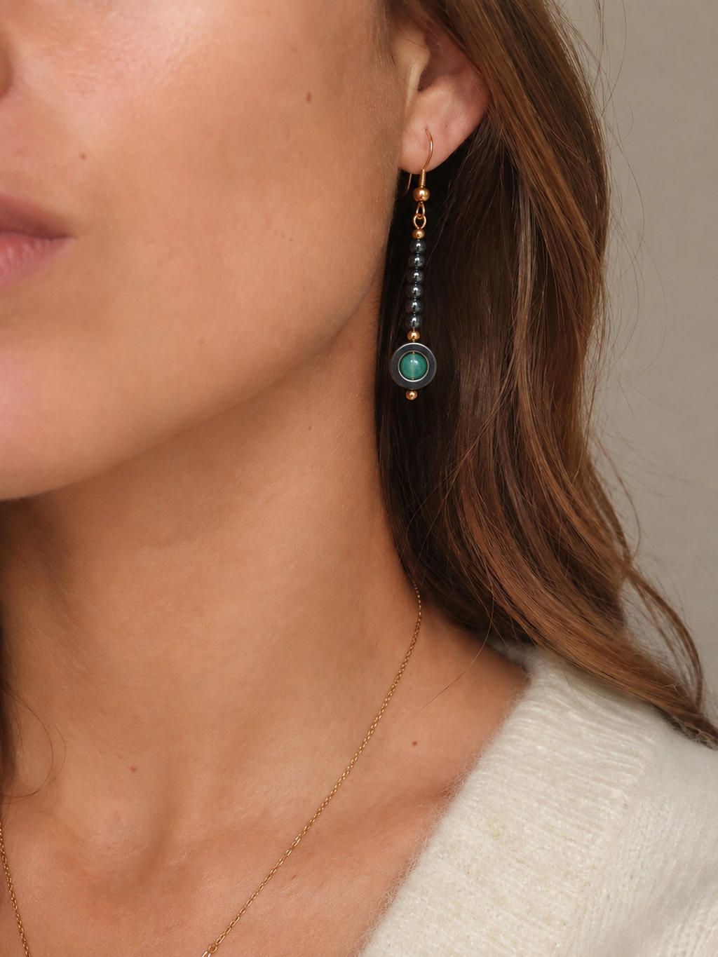 Boucles d'oreilles Borgia en hématites naturelles et dorées et perles en aventurine verte portées par un modèle