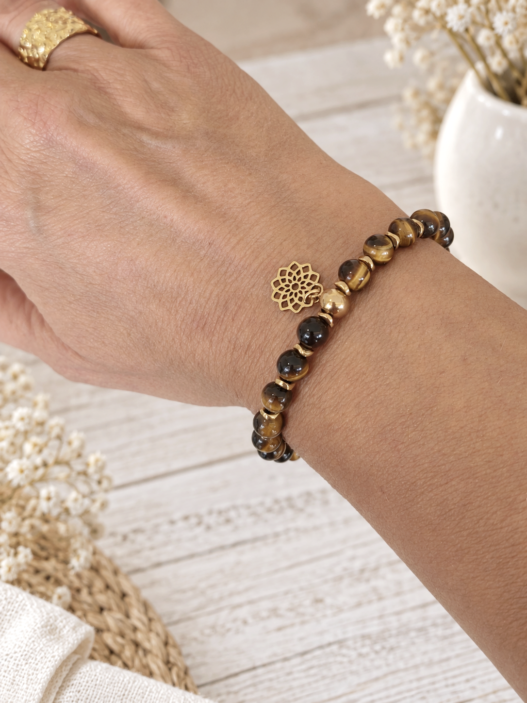 Bracelet œil de tigre 6mm avec intercalaires en hématite dorée et mandala en acier inoxydable porté par un modèle