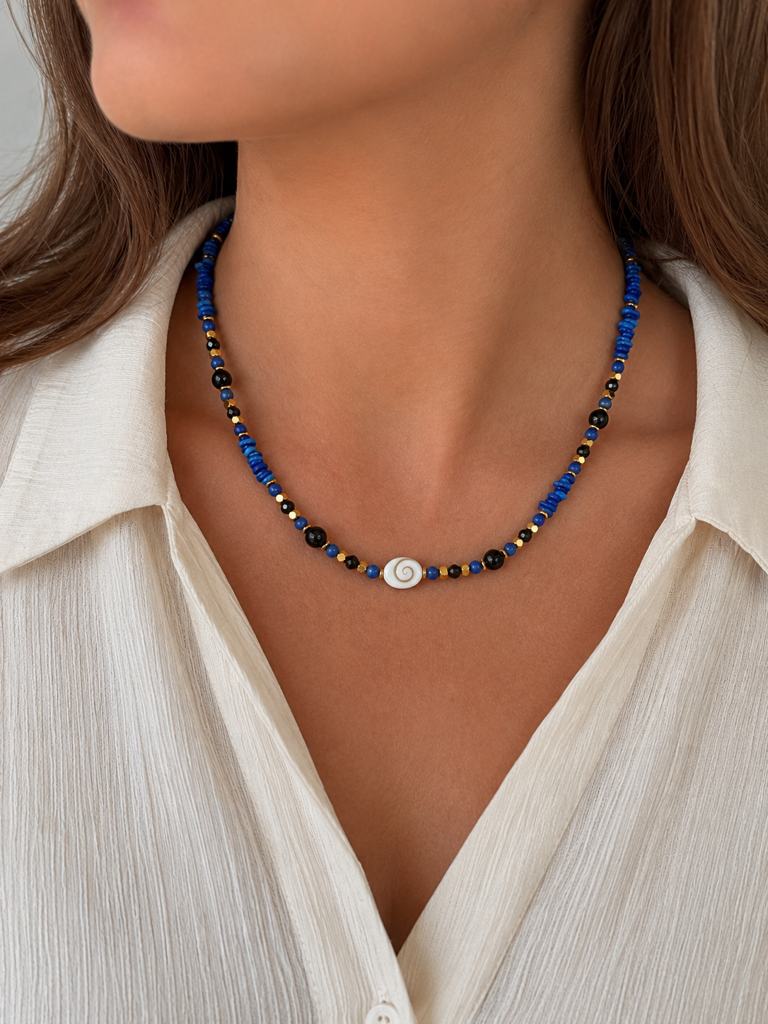 Collier Jaipur en lapis-lazuli, onyx, hématite dorée et l'œil de sainte Lucie porté par un modèle
