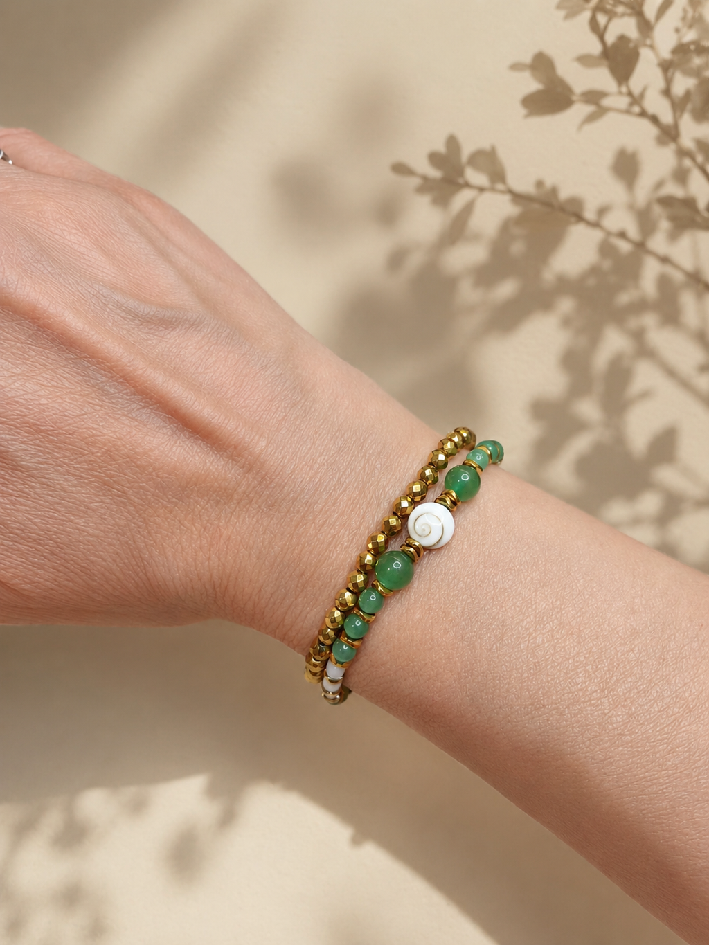 Duo de bracelets Doha aventurine et hématite facettée dorée portés par un modèle