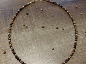 collier tour de cou perles en pierres naturelles oeil de tigre 4mm et hématite 3mm dorée sur fil d'acier avec fermoir mousqueton doré et chaine d'extension en acier inoxydable